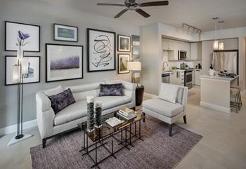 A living room with a white couch and a coffee table in front of it.